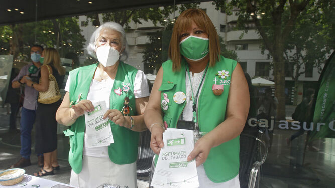 Dos voluntarias de la AECC muestran unos folletos sobre el Día Mundial sin Tabaco.