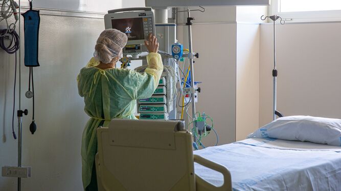 Una enfermera prepara una cama para un paciente covid.