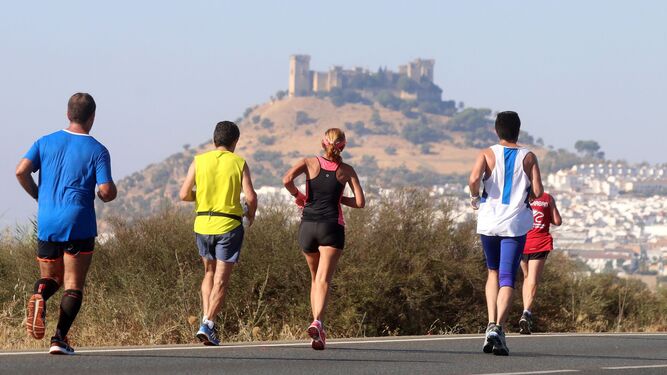 Varios corredores de la Media Maratón Córdoba-Almodóvar, con el emblemático castillo cuco al fondo.