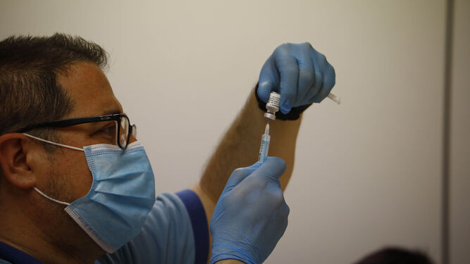 Un enfermero prepara una vacuna del covid.