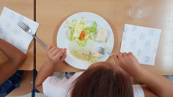 Una niña almuerza en un comedor escolar