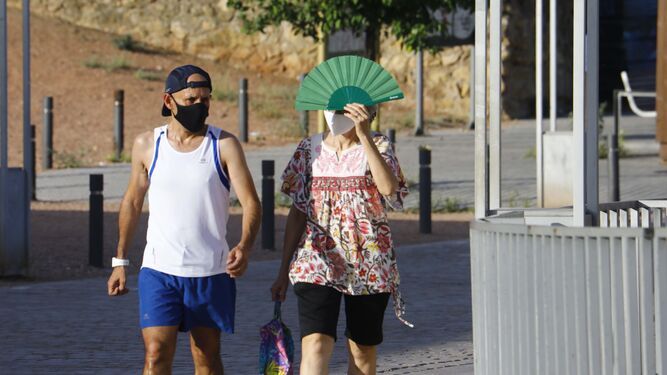Dos personas pasean bajo un sol de justicia en Córdoba.