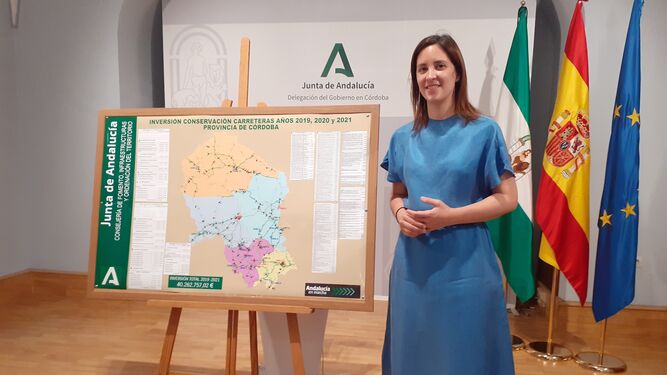 Cristina Casanueva junto al mapa de actuaciones en carreteras autonómicas de Córdoba.