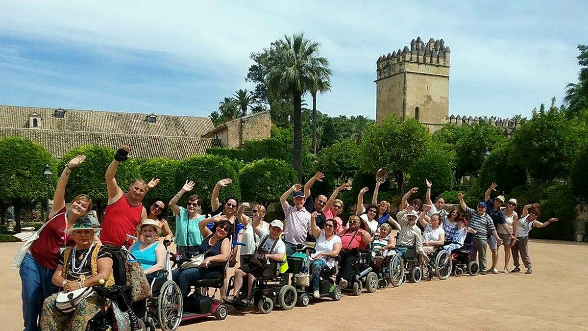 Un grupo de turistas con movilidad reducida en los jardines del Alcázar