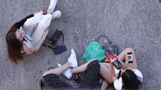 Unas jóvenes realizan botellón en plena calle.