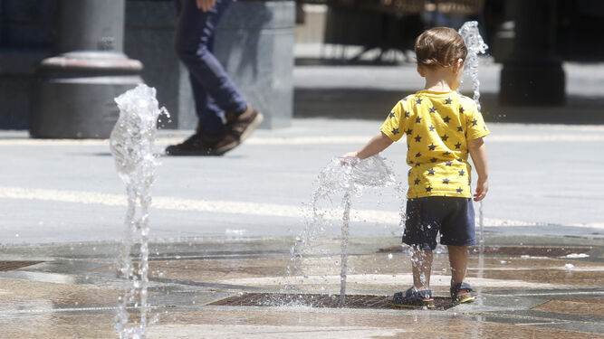 Un niño se refresca en las fuentes de plaza de las Tendillas.
