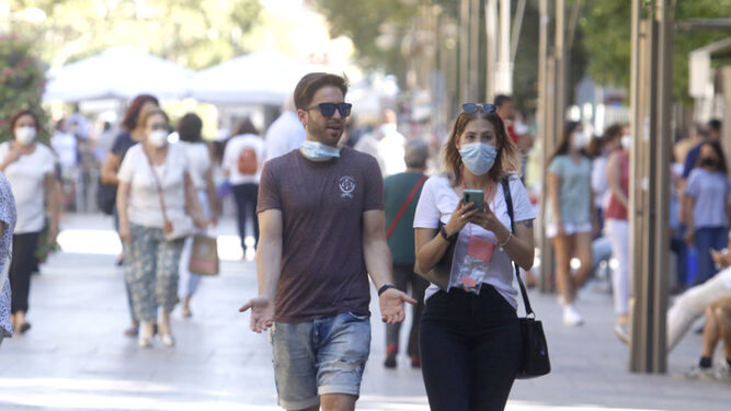 Un hombre y una mujer caminan por el centro de Córdoba.