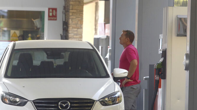 Un hombre reposta gasolina en su coche en una estación de servicio de Córdoba capital.