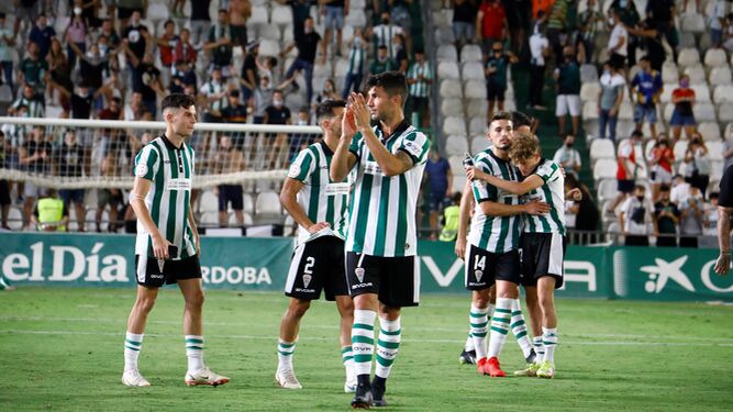 Willy aplaude a la afición del Córdoba CF tras el partido ante el Cádiz B, con sus compañeros abrazándose de fondo.