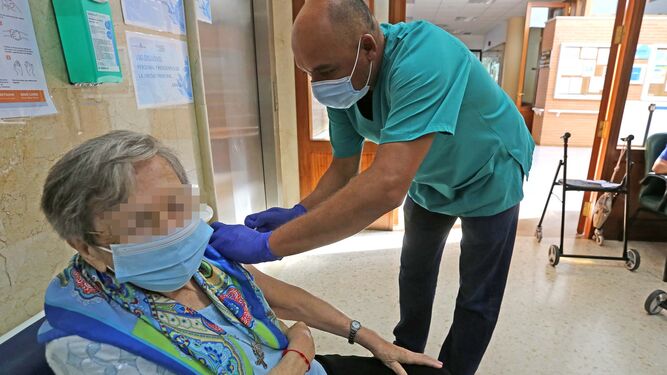Una usuaria del hospital San Juan Grande de Jerez recibiendo la tercera dosis de la vacuna