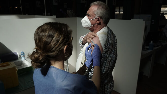 Una enfermera pone una vacuna contra el covid-19 a un hombre.
