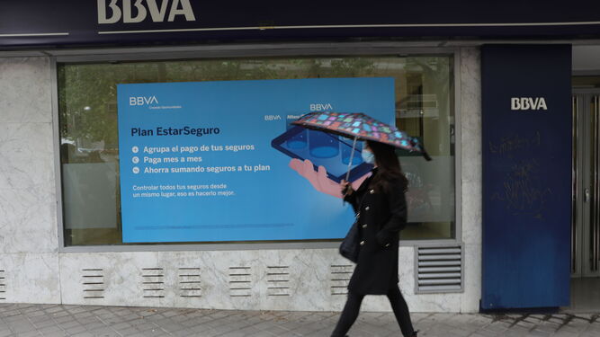 Una persona pasa por delante de la puerta de una Oficina de BBVA  en Madrid.
