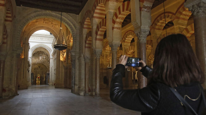 Una mujer toma una fotografía en el interior de la Mezquita-Catedral de Córdoba.