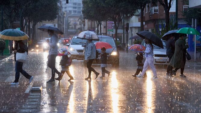 Personas se protegen de la lluvia en imagen de archivo.