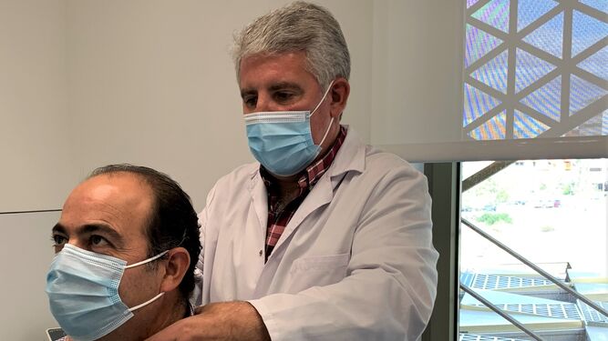 El doctor Palomares realiza un reconocimiento de un paciente en consulta.