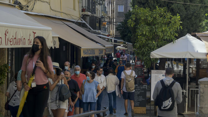 Personas con y sin mascarilla en una calle de Granada.