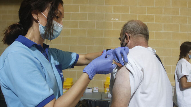 Una profesional sanitaria inyecta la vacuna contra el coronavirus  una persona.