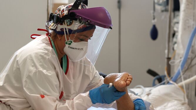 Una enfermera hace rehabilitación a un paciente con covid.