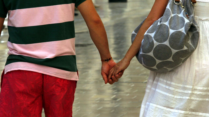 Una pareja pasea de la mano.
