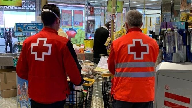 Dos voluntarios de Cruz Roja recogen alimentos en uno de los supermercados de Piedra.
