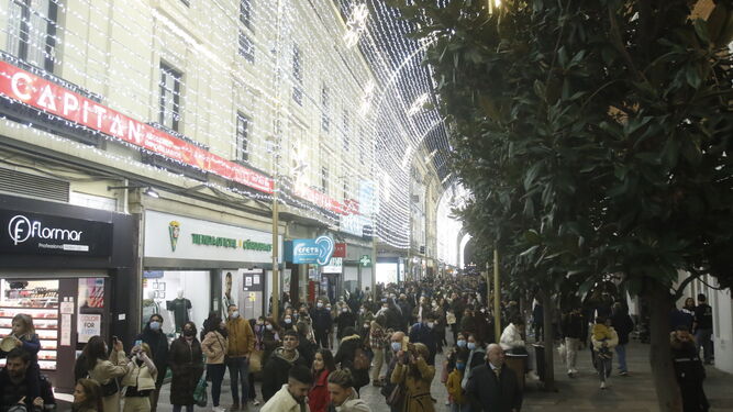 Numerosas personas pasean por la una iluminada calle Cruz Conde.