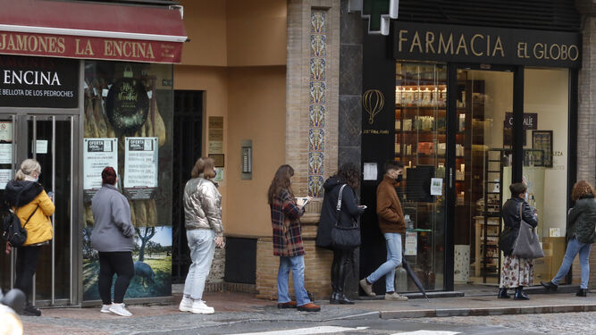 Varias personas esperan para entrar en una farmacia de Córdoba.