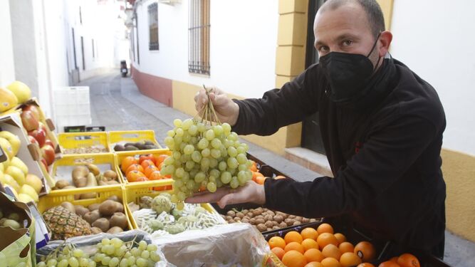Javier, de la frutería Casa Francisco, sostiene unos racimos de uvas para esta Nochevieja.