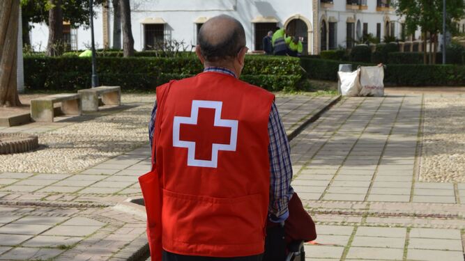 Un voluntario de Cruz Roja acompaña a una persona mayor.