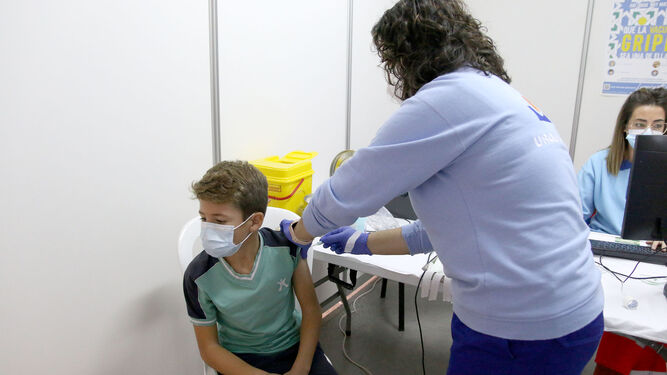 Una enfermera inocula a un menor una dosis de la vacuna contra la Covid- 19