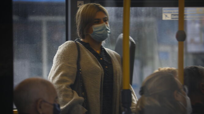 Una mujer, protegida por su mascarilla, viaja en un autobús de Aucorsa.