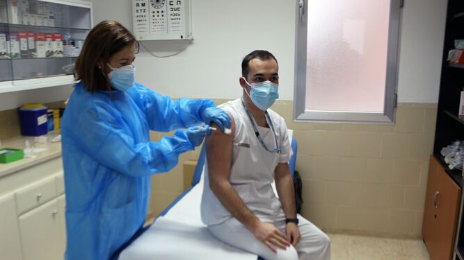 Una enfermera pone una vacuna contra el covid a un hombre.