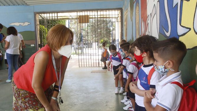 La directora de un colegio recibe a los alumnos, con mascarillas, el primer día de clase.