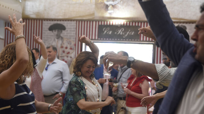 Varias personas bailan en el interior de una caseta de la Feria de 2019.