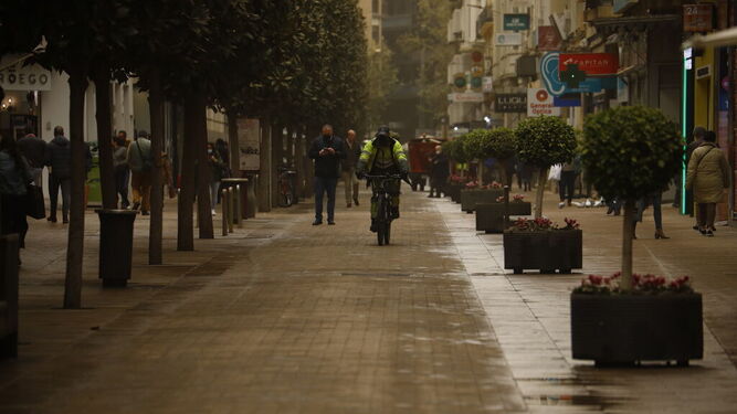 Varias personas en la calle Cruz Conde de Córdoba bajo la calima.