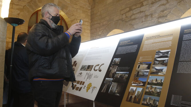 Una persona realiza fotografías a uno de los paneles de la muestra.