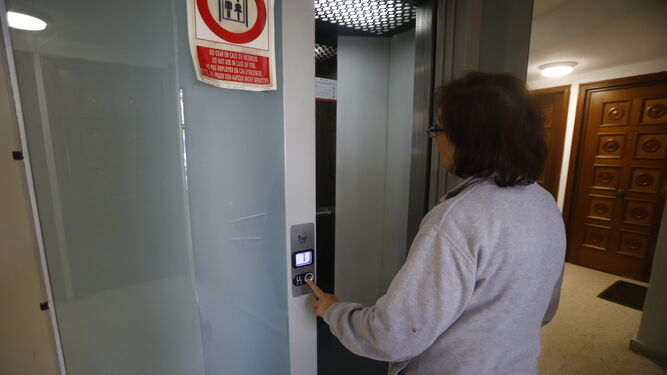 Una mujer se sube al ascensor de su bloque de pisos en Córdoba.