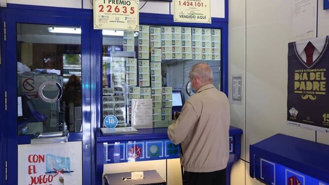 Un hombre compra lotería en una administración.