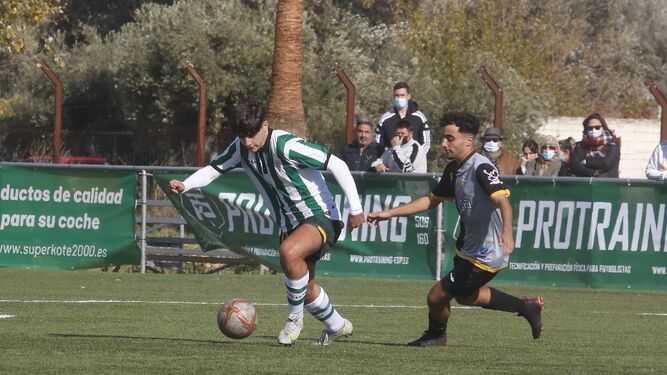 Un jugador del CCF juvenil lucha contra un rival del Sporting Atlético.