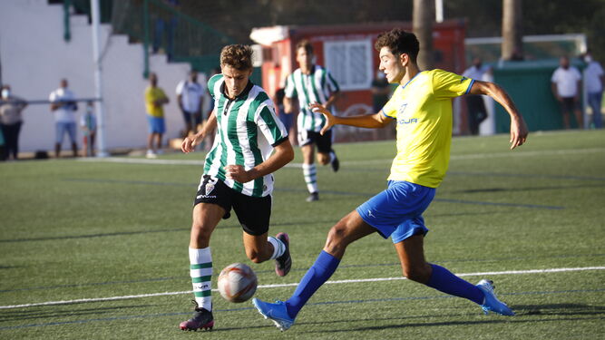 Un jugador del Córdoba CF juvenil conduce el balón ante la presión rival.