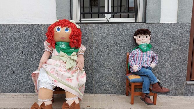 Muñecas de la más variada índole esperan el paso de los vecinos a las puertas de la casas en Cardeña