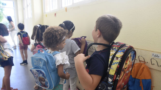 Un niño se pone la mochila en un colegio.