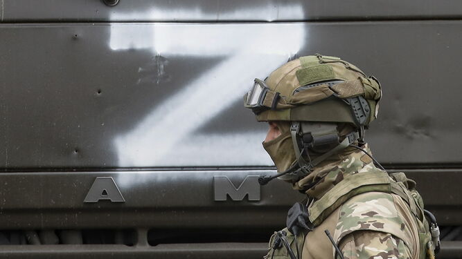 Un soldado ruso ante un camión marcado con una Z.