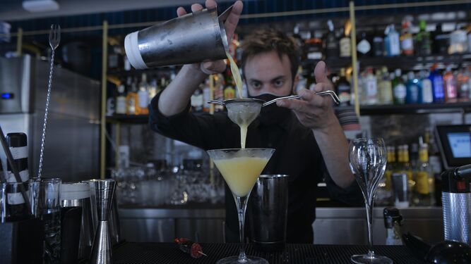 Un camarero prepara un cóctel en un bar.