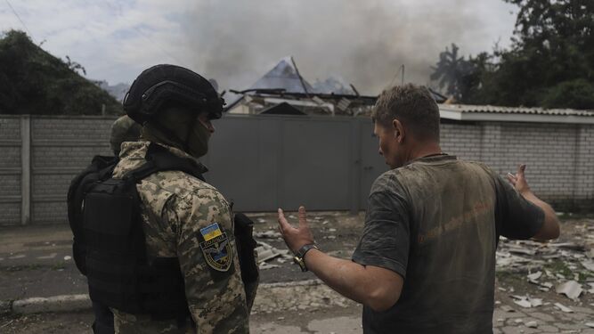 Un soldado ucraniano habla con un residente en la localidad de Lysychiansk, en la región de Lugansk, tras un ataque ruso.