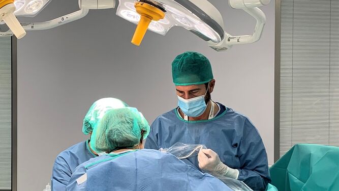 Los doctores Espiñeira (de espaldas) y Contreras realizan una biopsia de ganglio centinela en quirófano.