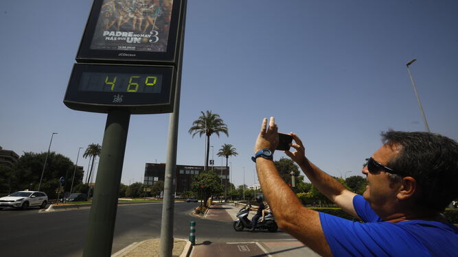 Un hombre le hace una foto a un termómetro que marca 46 grados en Córdoba.