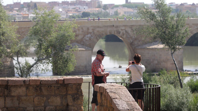 Dos personas en el entorno del río Guadalquivir en Córdoba.
