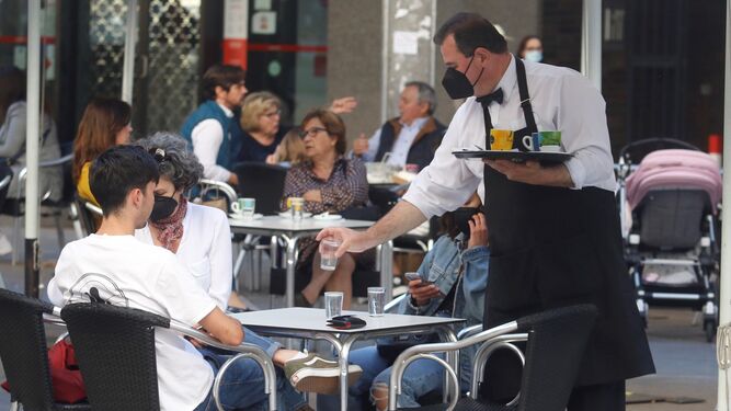 Un camarero atiende una mesa en un bar de Córdoba.