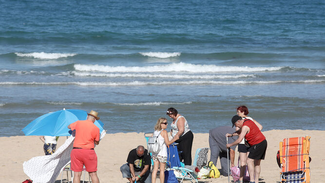 Varias personas de una excursión se instalan a su llegada a la playa.