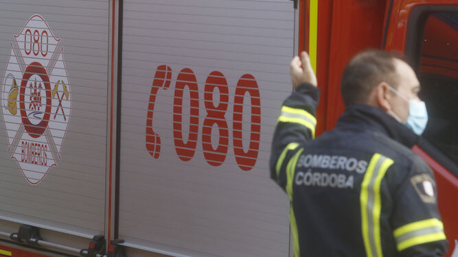 Un efectivo del cuerpo de bomberos de Córdoba, junto a uno de los vehículos de la flota.